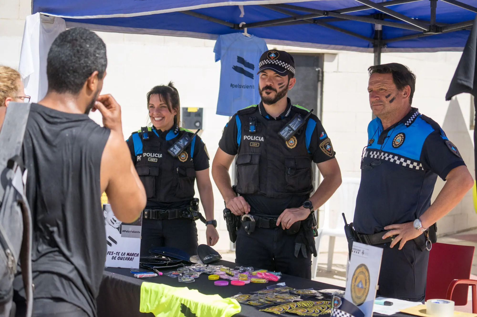 Agents de la Policia Local estan dempeus amb marxandatge solidari