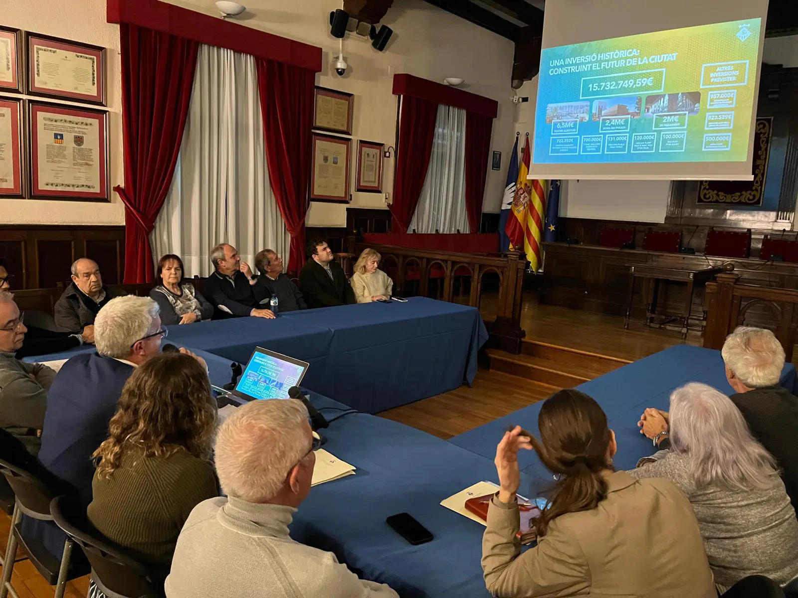 L'alcalde Eduard Sanz presenta el pressupost davant diverses persones que representen a les entitats veïnals i que estan assegudes al voltant d'una taula al Saló de Plens