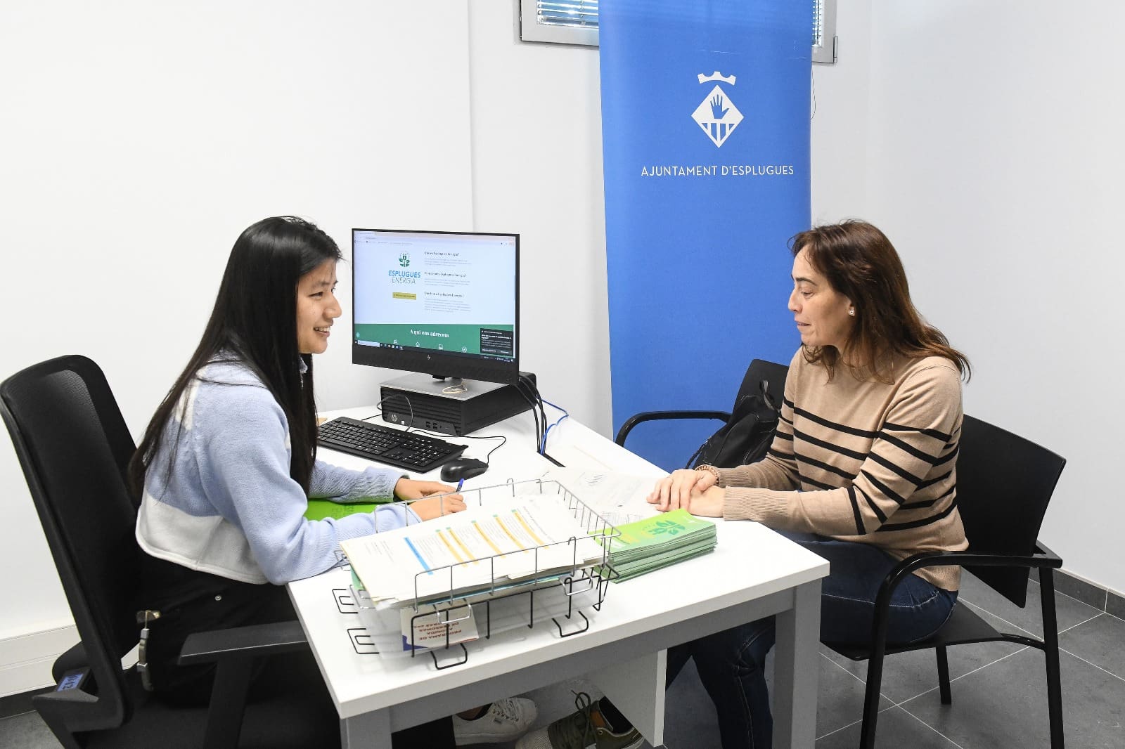 Una persona del servei Esplugues Energia atén a l'oficina a una ciutadana